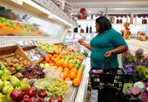 Non- Diet Approach to eating disorder counseling in Los Angeles, California [Image description: photo of a larger black woman shopping for fruit] represents a potential patient seeking therapy for an eating disorder in Los Angeles, California
