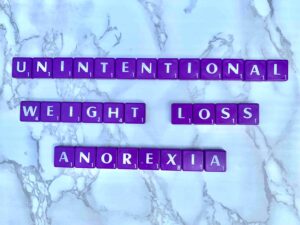 Unintentional Weight Loss as a Trigger for Anorexia in Los Angeles, California [Image description: purple scrabble tiles spelling "Unintentional Weight Loss Anorexia" 