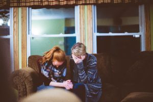 Grief and Eating Disorder Recovery in Los Angeles, California [Image description: photo of two woman looking down and sitting close] Represents a potential person in eating disorder recovery in California who is grieving 