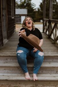 Body neutrality and positivity [Image description: photo of a larger-bodied white woman sitting on a step and looking joyful] Represents a potential person with an eating disorder in California 