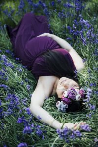 Body Comments and Pregnancy [Image description: photo of a pregnant woman in a purple dress laying in a field and holding her belly] Represents a pregnant woman feeling positive about her body