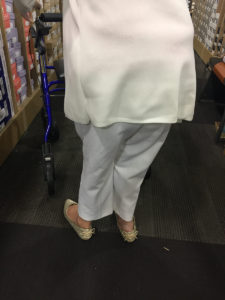 buying bigger clothes [image description: my grandmother walking through shoe store with her walker]