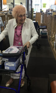 buying bigger clothes [image description: photo of my grandmother walking through a shoe store with her walker]