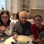 Connection through food and poundcake [Image description: photo of an old woman holding a poundcake and surrounded by two young girls] Represents eating disorder therapy in California 