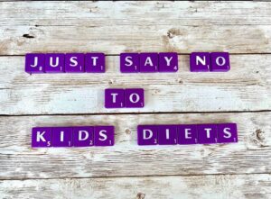 Just say no to kids' diets in Los Angeles, California [Image description: purple scrabble tiles spelling "Just say no to kids diets']