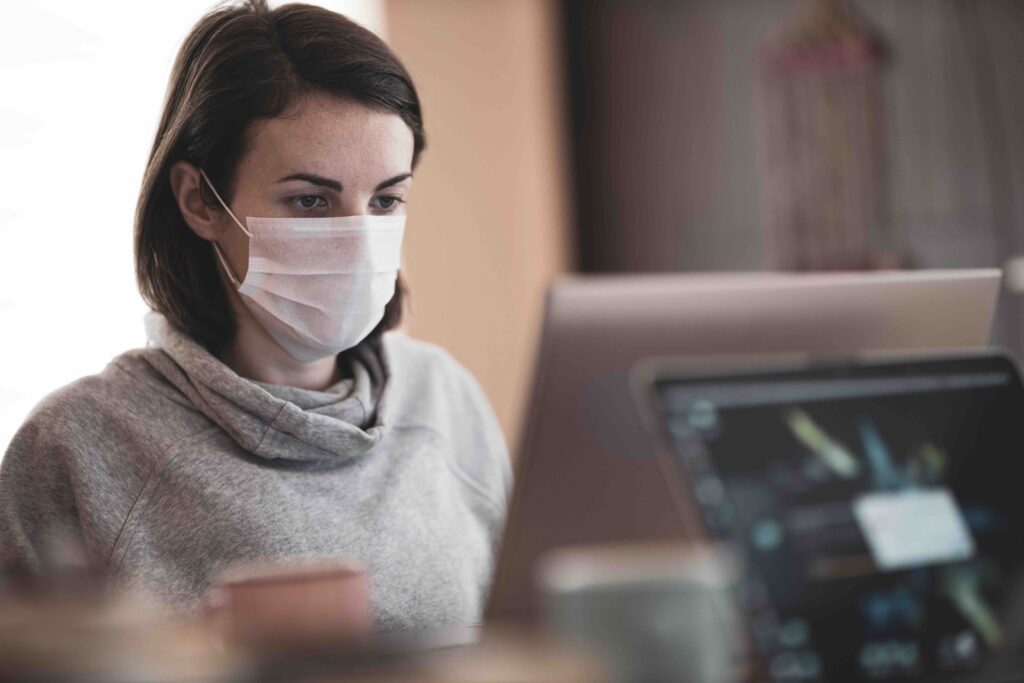College, COVID, and Eating Disorders [Image description: woman with mask in front of computer]