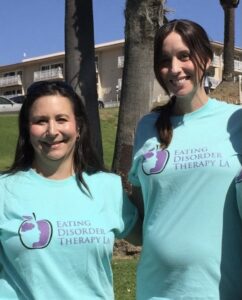 The History of Eating Disorder Therapy LA [Image description: photos of 2 dark-haired women wearing t-shirts with Eating Disorder Therapy LA and the logo on the shirt; Dr. Carcieri is pregnant]