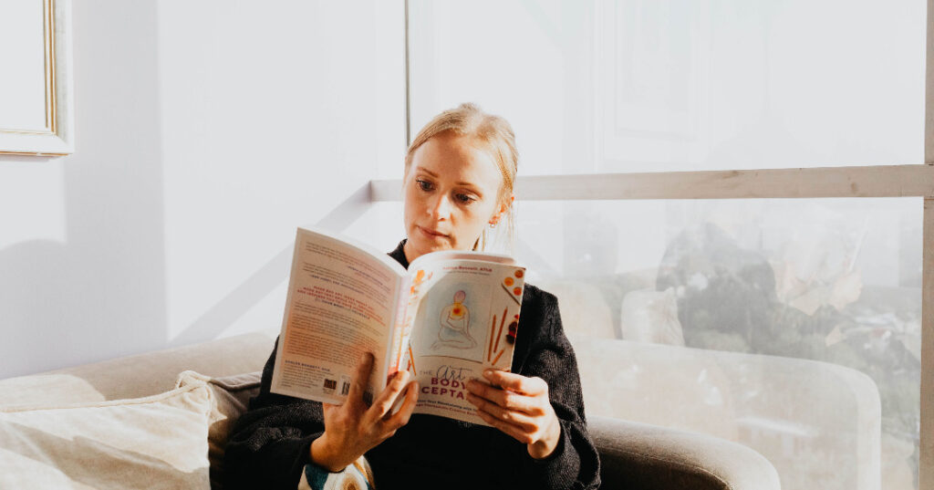 Recommended reading and Resources for Eating Disorders in Los Angeles, California [Image description: photo of a woman reading a book in front of a window] Represents a potential client seeking treatment for an eating disorders in Los Angeles, California