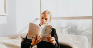 Recommended reading and Resources for Eating Disorders in Los Angeles, California [Image description: photo of a woman reading a book in front of a window] Represents a potential client seeking treatment for an eating disorders in Los Angeles, California
