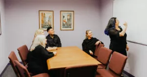 Training eating disorder staff and graduate students in eating disorder therapy in Los Angeles, California [Image description: photo of Dr. Muhlheim using the white board to train other eating disorder therapists]