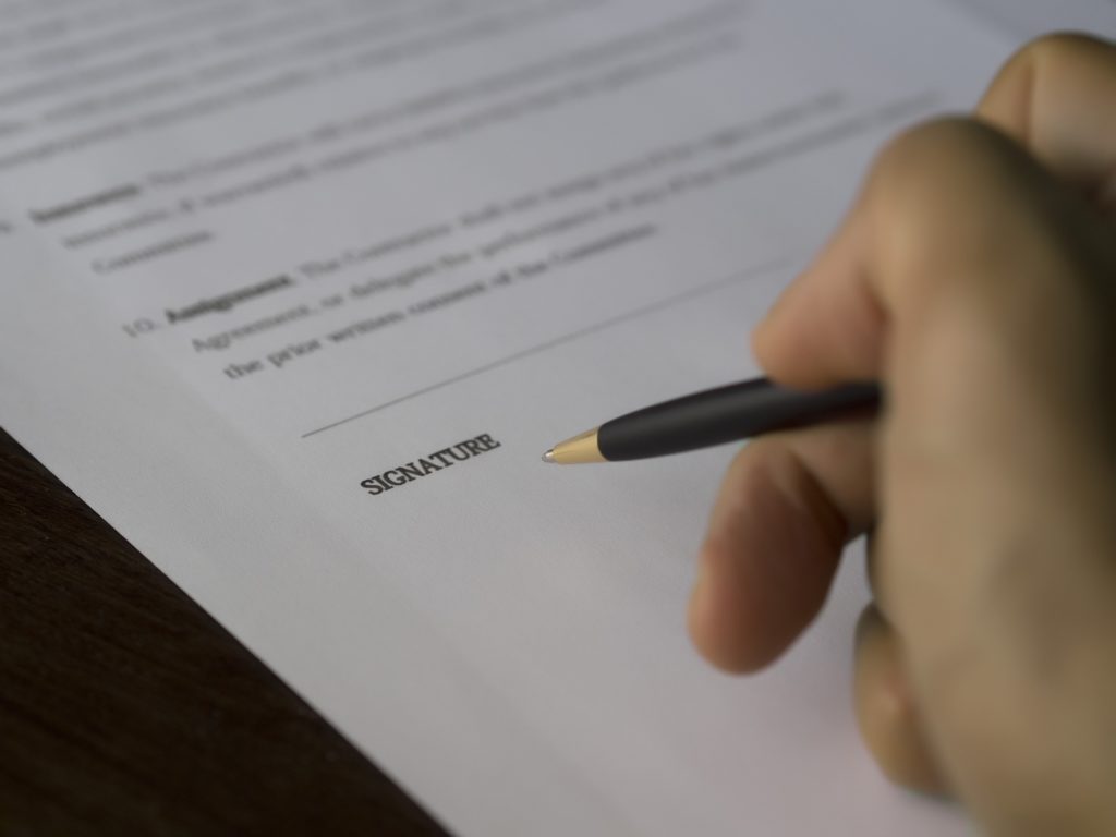 Eating Disorder College Contract in Los Angeles, CA [Image description: photo of a hand signing a contract] representing a potential college contract for a hopeful college student with an eating disorder in California