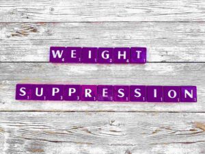 Weight Suppression in Eating Disorders in Los Angeles, California [Image description: purple scrabble tiles spelling "weight suppression"]