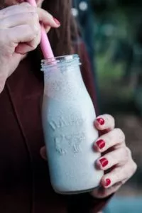 Dairy and Eating Disorder Recovery in Los Angeles, California [Image description: a person driving a bottle of milk through a straw] Illustrating a potential person in eating disorder recovery incorporating milk