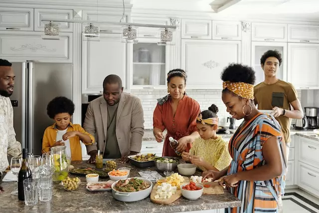 Supporting Child with Eating Disorder Over Holiday in Los Angeles, California [Image description: photo of a Black family preparing a meal together and all the family members are dressed up] represents a potential family supporting a loved one with an eating disorder during the holidays