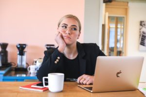 Is Restriction Driving Your Obsessive Food Thoughts [image description: business woman at computer looking distracted because she is hungry] Represents a potential patient seeking help for disordered eating in Los Angeles, California