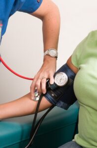 Medical Clearance for Outpatient Eating Disorder Therapy in Los Angeles, CA [image description: the arm of a patient having her blood pressure taken by a health professional representing a potential person in California receiving treatment for an eating disorder]