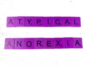 Therapy for Atypical Anorexia in Los Angeles, CA [Image description: Purple scrabble tiles spelling "Atypical Anorexia"]