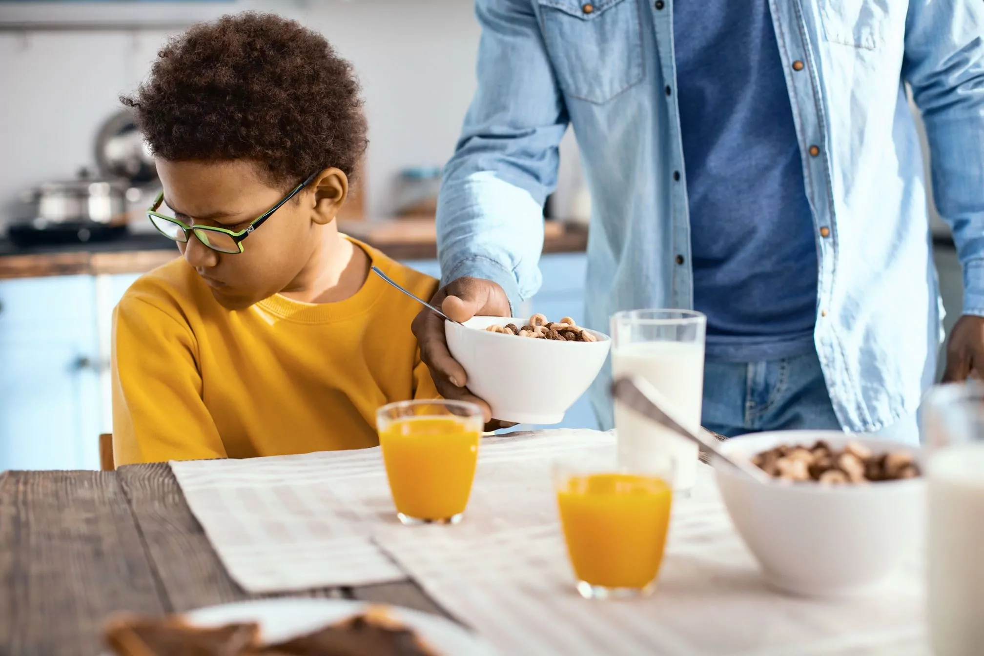 Therapy for ARFID in Children in California [Image description: a boy eating breakfast of cereal and juice and looking unhappy] Represents a potential client receiving counseling for ARFID in California