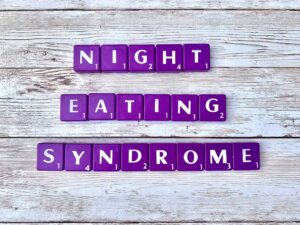 Night Eating Syndrome in Los Angeles, California [Image description: purple scrabble tiles that spell "Night Eating Syndrome"]