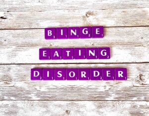 Binge Eating Disorder Treatment in Los Angeles, California [Image description: purple scrabble tiles spelling BED down and "Binge Eating Disorder"]