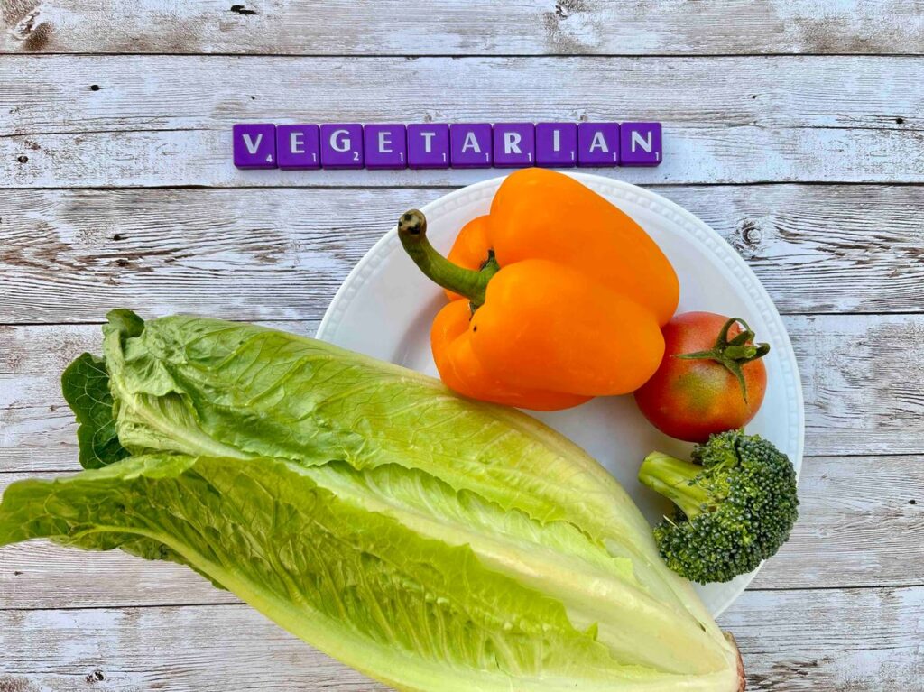 Should you let your teen become vegetarian [Image description: purple scrabble tiles spelling "vegetarian" above a plate with raw vegetables]