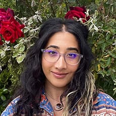 Shadi Houshangi [Image description: photo of therapist Shadi, smiling in front of a flowering tree]