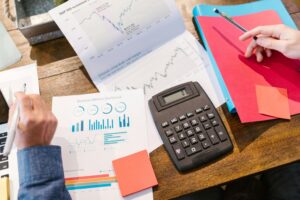 Private equity and eating disorders [Image description: financial documents and a calculator on a desk] depicts potential analysis of investment in an eating disorder facility