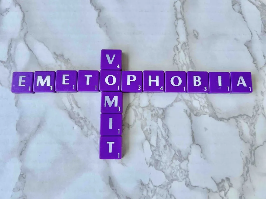 Therapy for Emetophobia--specific fear of vomiting [Image description: purple scrabble tiles spelling out "emetophobia" & "vomit."]