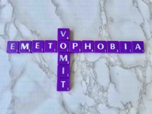 Therapy for Emetophobia--specific fear of vomiting [Image description: purple scrabble tiles spelling out "emetophobia" & "vomit."]