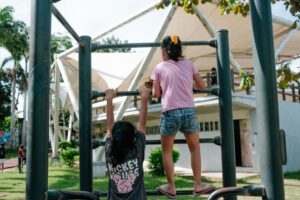 kids in playground may be avoided by people with emetophobia fear of vomiting [Image description: 2 children on a play structure] represents something a person with emetophobia in California may avoid 
